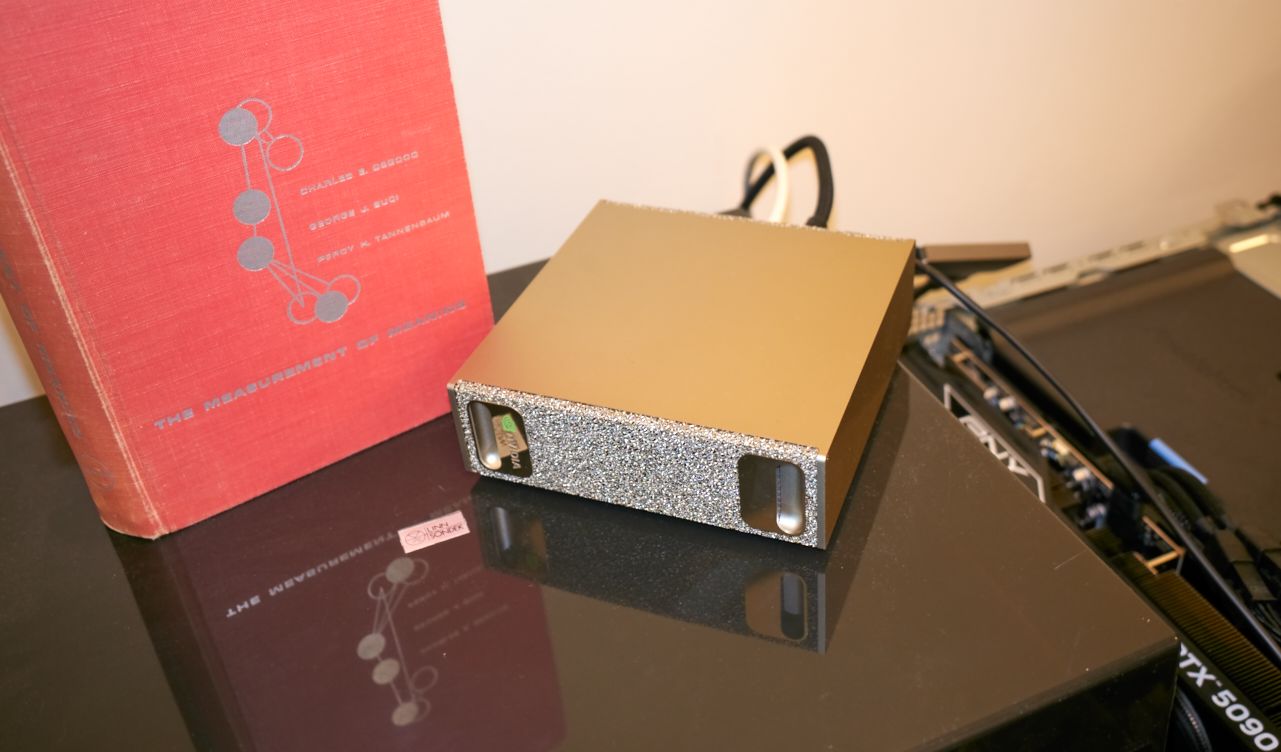 An NVIDIA DGX Spark desktop workstation beside The Measurement of Meaning.